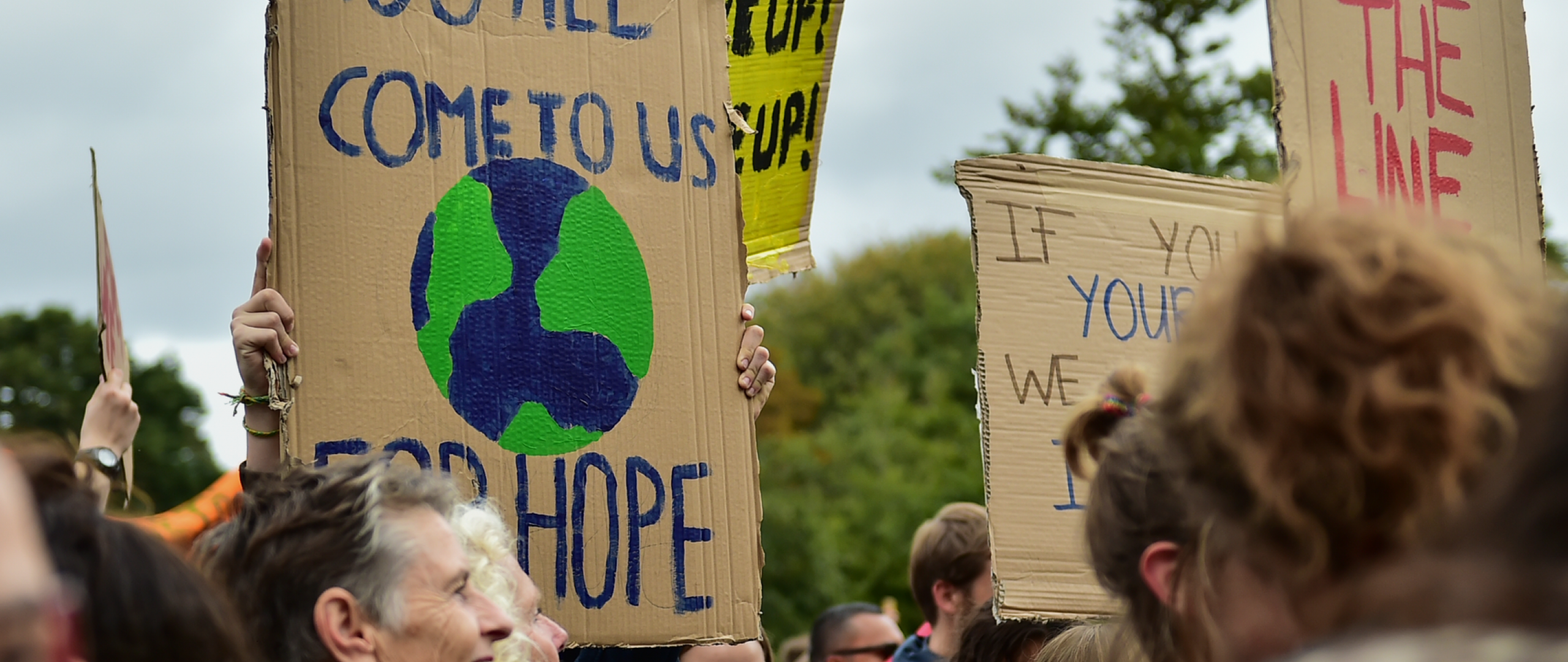 Klimaatdemonstranten met protestborden